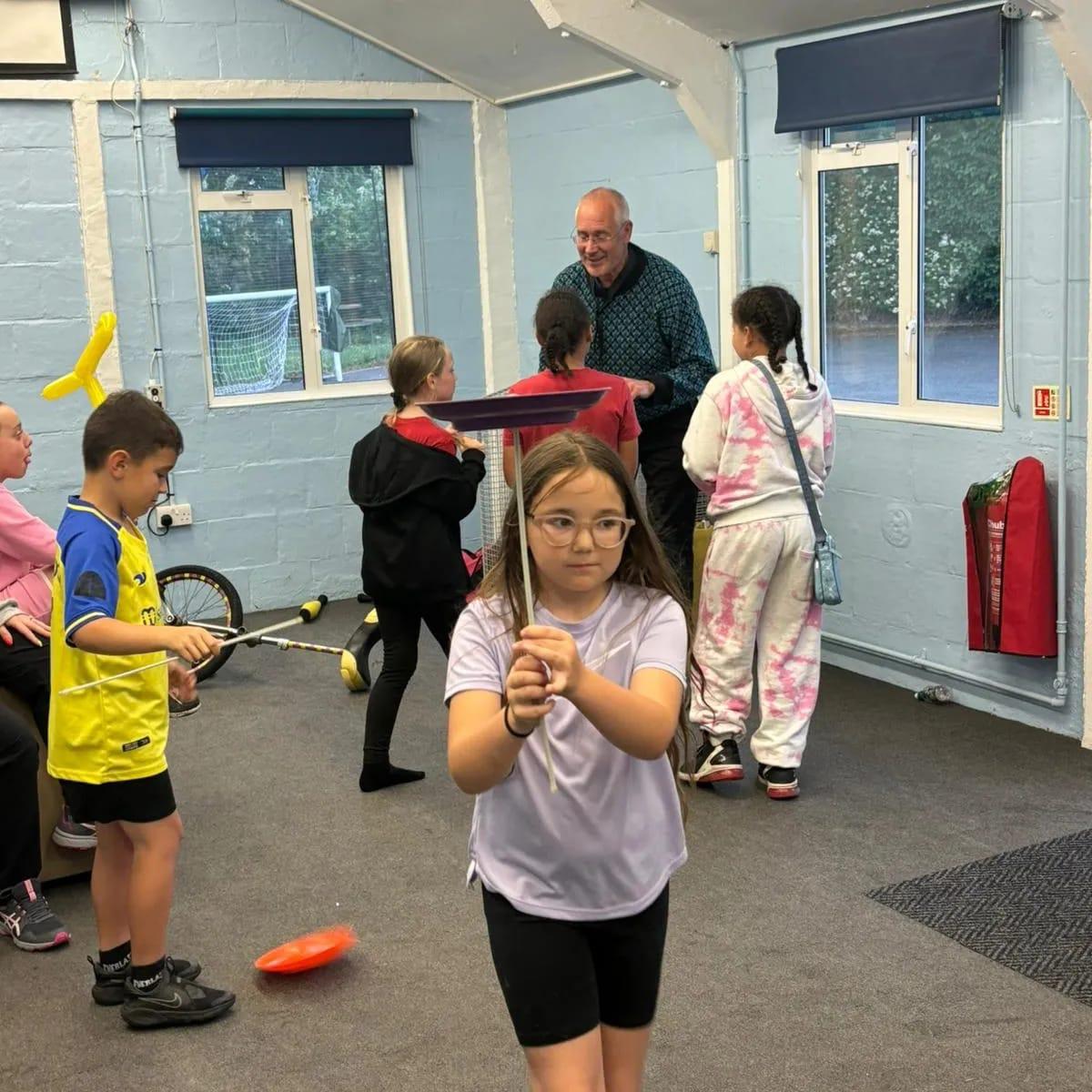 Children taking part in a colourful club activity indoors.